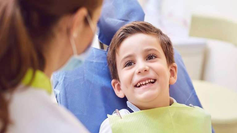 Kid smiling during dental check up at Sparkling Dental