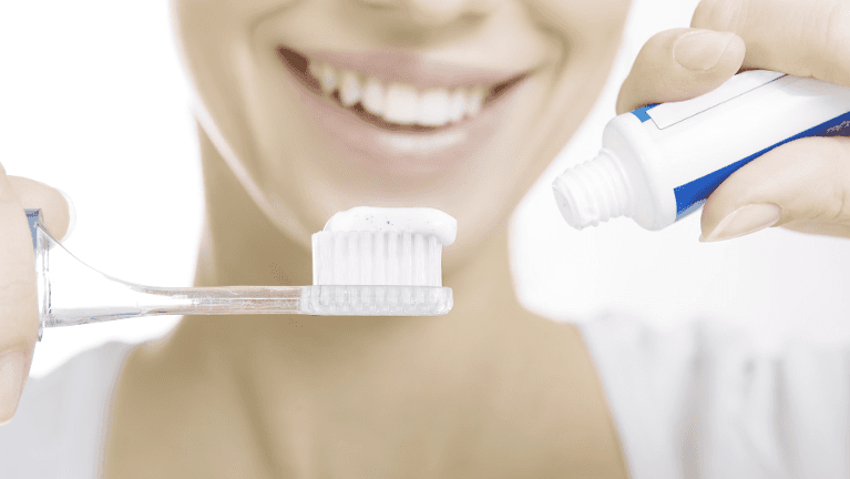 Lady placing toothpaste on the toothbrush in Neutral Bay, NSW