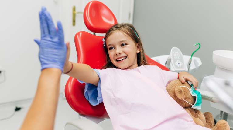 Kid playing with a dentist during dental check up at Sparkling Dental