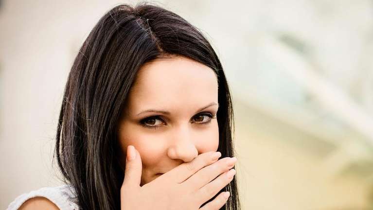 A smiling lady covering her mouth with her hand in Neutral Bay, NSW.