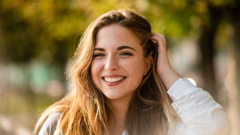 A woman smiling after a visit to the dentist in Neutral Bay, NSW