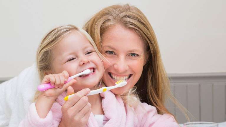 Mother teaching daughter how to brush her teeth in Neutral Bay, NSW