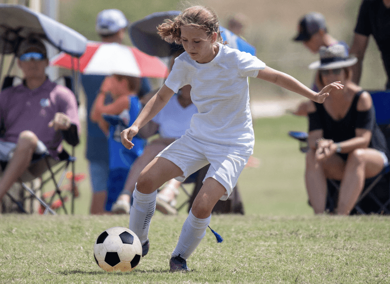Girl playing football with a mouthguard from Sparkling Dental