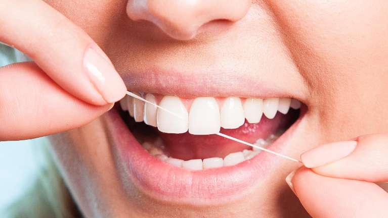 Patient flossing her teeth in Neutral Bay, NSW